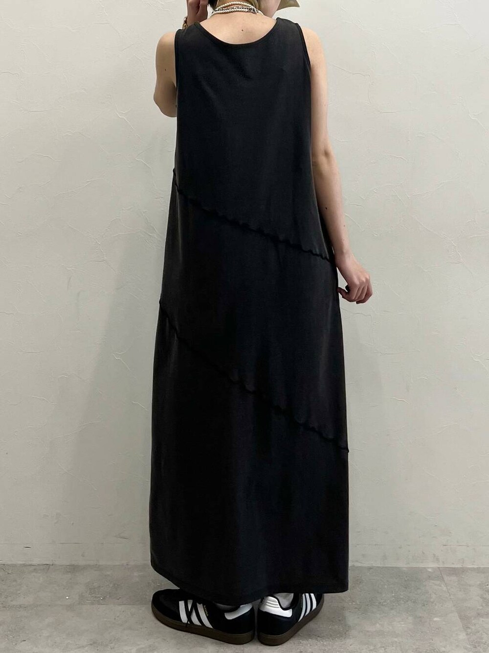 ブラック系のスニーカー、ブラック系のワンピース、ホワイト系のネックレスを着用したレディースの春コーディネートの5枚目の写真