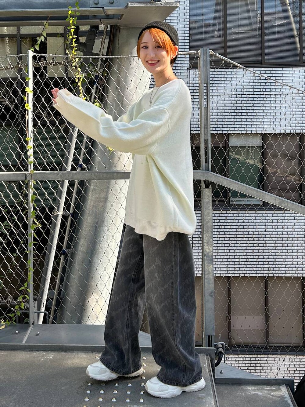 ブラック系のデニムパンツ、ホワイト系のニット/セーター、ブラック系のニットキャップ/ビーニーを着用したレディースの冬コーディネートの4枚目の写真
