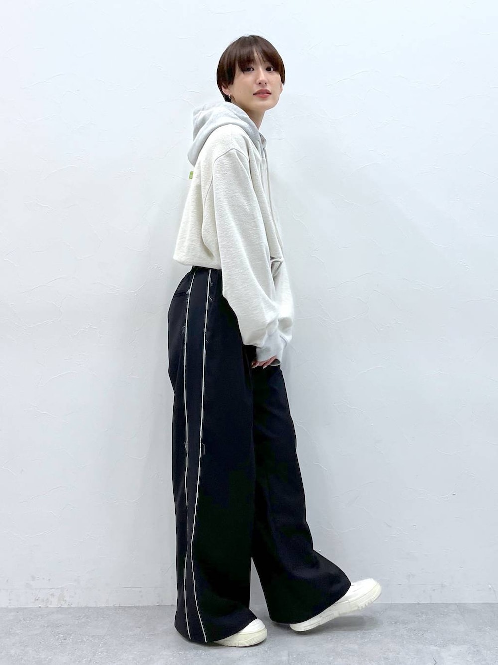 ブラック系のスラックス、グレー系のパーカーを着用したレディースの秋コーディネートの5枚目の写真