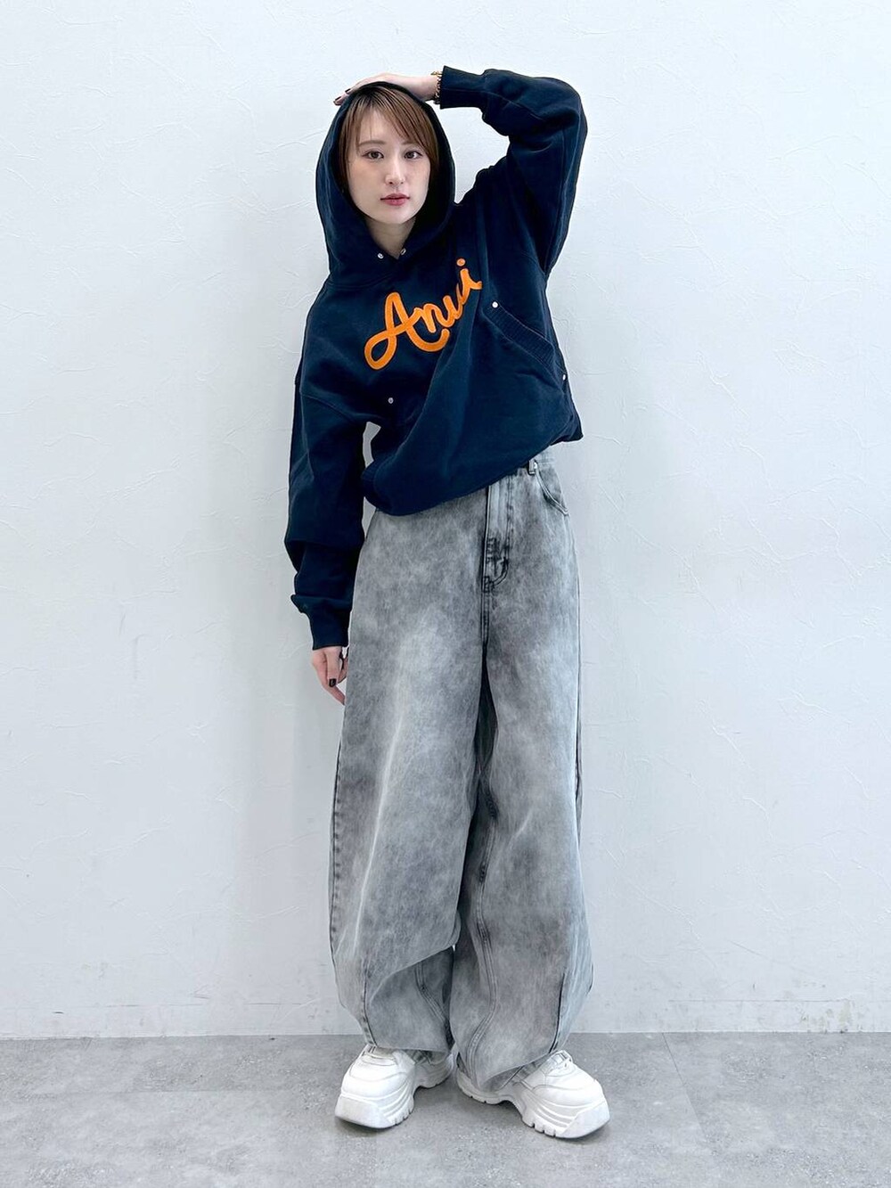 ブルー系のパーカー、ブラック系のデニムパンツを着用したレディースの春コーディネートの2枚目の写真