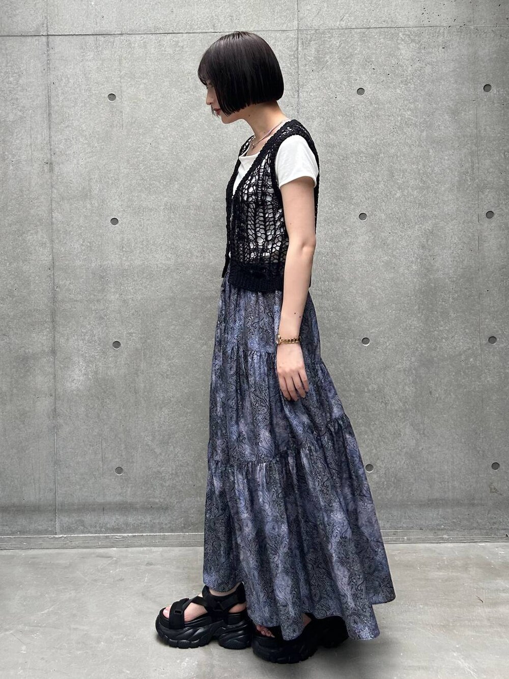 ブラック系のサンダル、ホワイト系のTシャツ/カットソー、ブラック系のスカートを着用したレディースの夏コーディネートの3枚目の写真