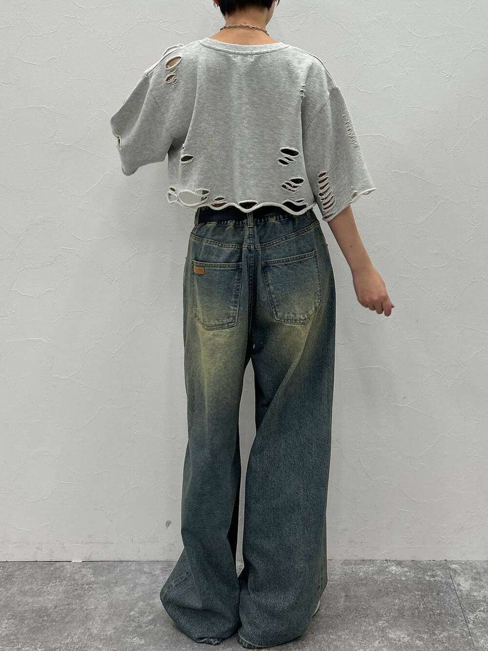 グレー系のTシャツ/カットソー、ブルー系のデニムパンツ、グリーン系のキャップを着用したレディースの秋コーディネートの8枚目の写真