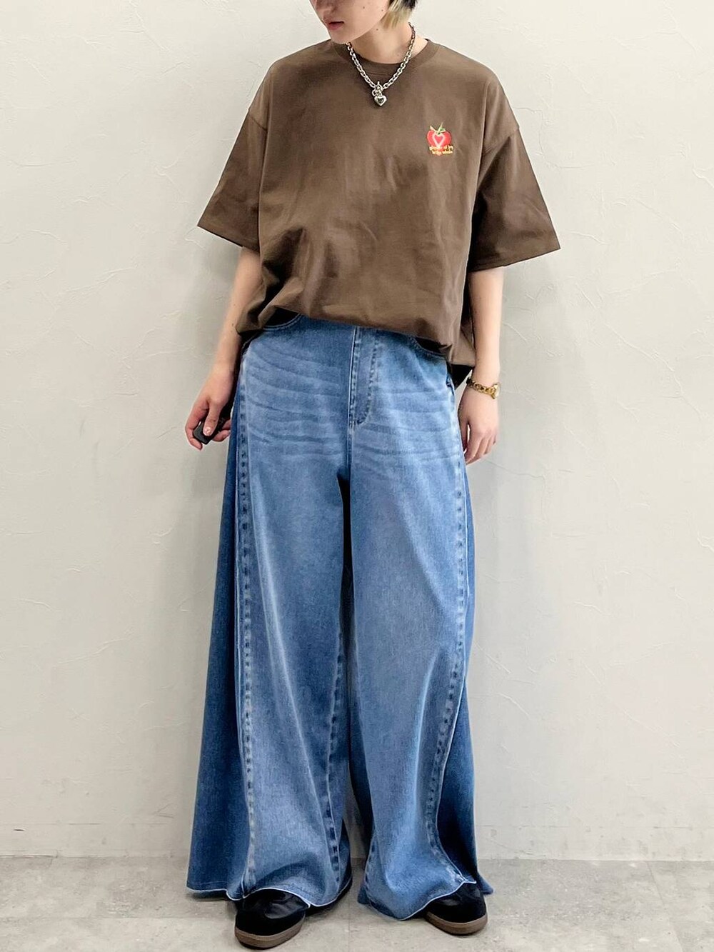 ブルー系のデニムパンツ、ブラック系のスニーカー、ブラウン系のTシャツ/カットソーを着用したレディースの春コーディネートの8枚目の写真