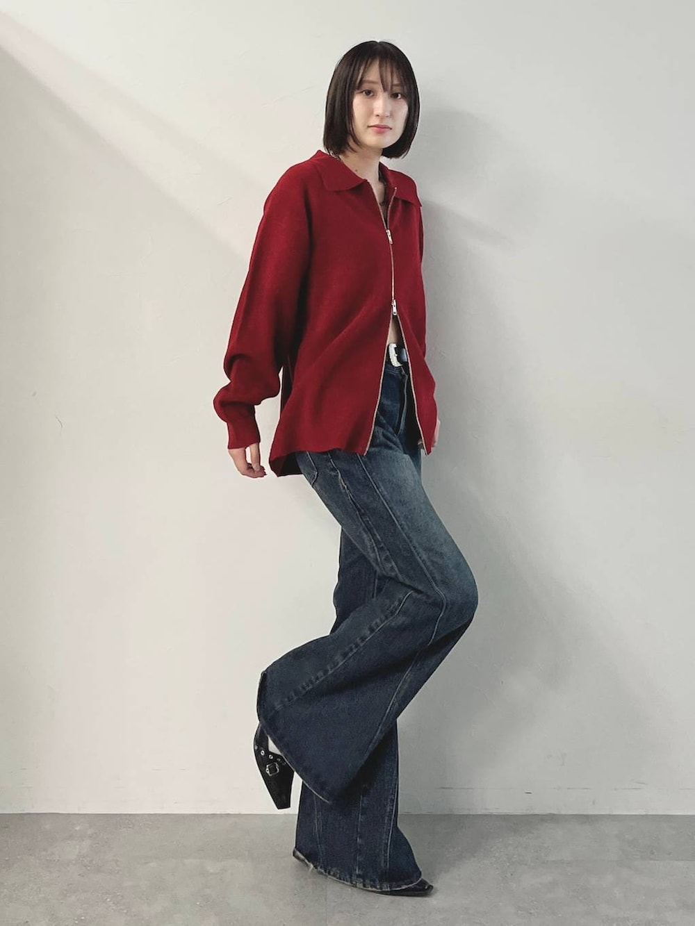 ブラック系のキャミソール、ブルー系のデニムパンツ、ブラック系のパンプスを着用したレディースの秋コーディネートの5枚目の写真