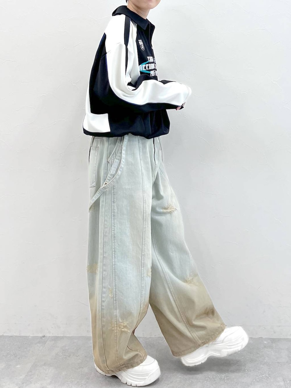 ブラック系のポロシャツ、ブルー系のデニムパンツを着用したレディースの春コーディネートの5枚目の写真