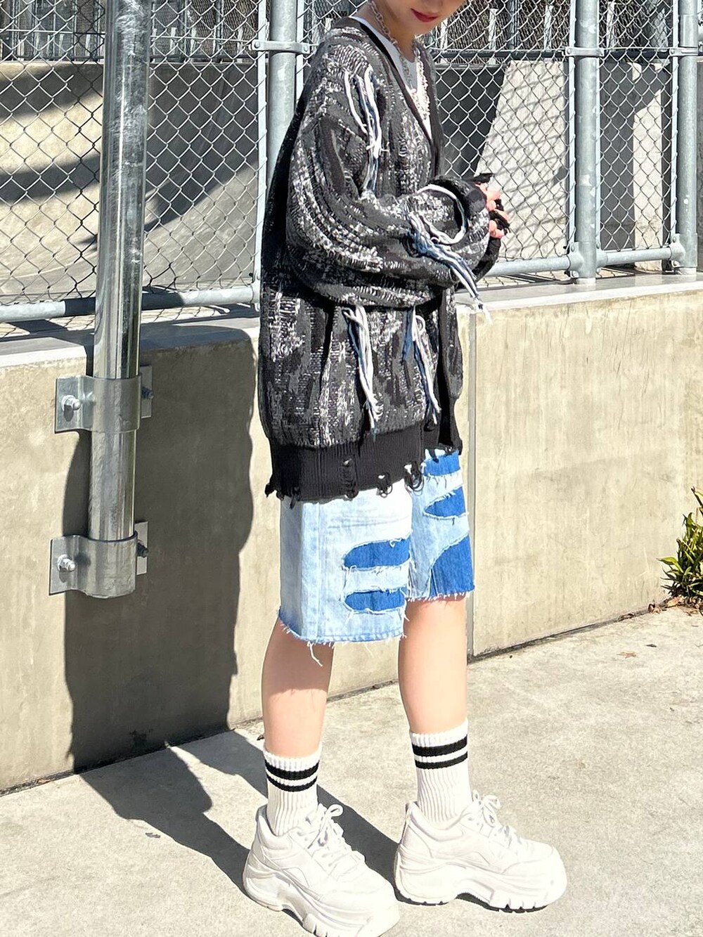 ホワイト系のTシャツ/カットソー、ブラック系のカーディガン/ボレロ、ブルー系のデニムパンツを着用したレディースの春コーディネートの5枚目の写真