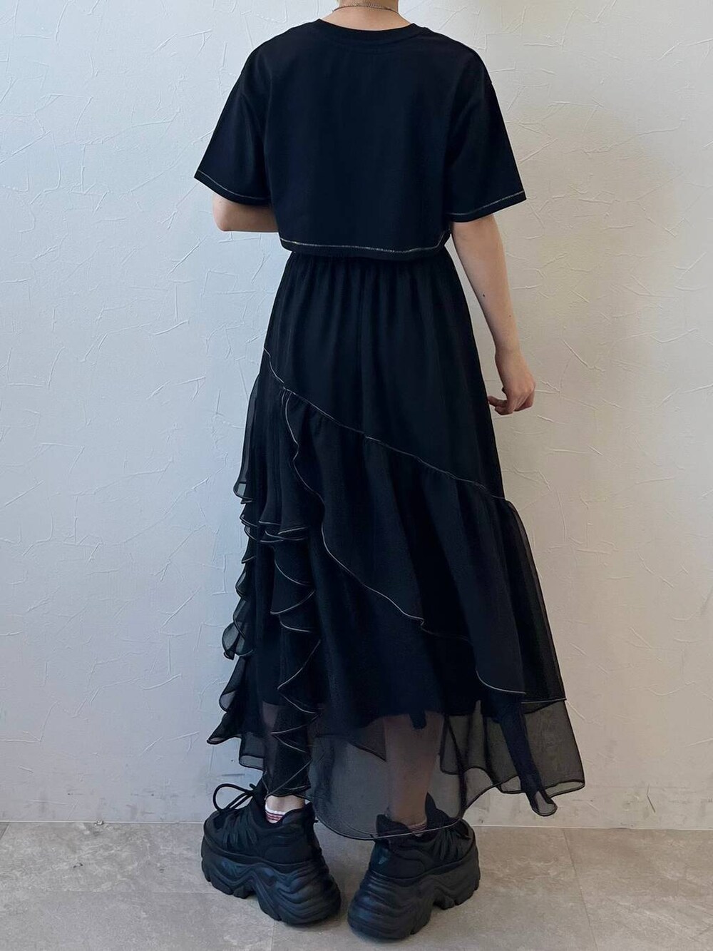 ブラック系のスニーカー、ブラック系のスカート、ブラック系のTシャツ/カットソーを着用したレディースの春コーディネートの8枚目の写真