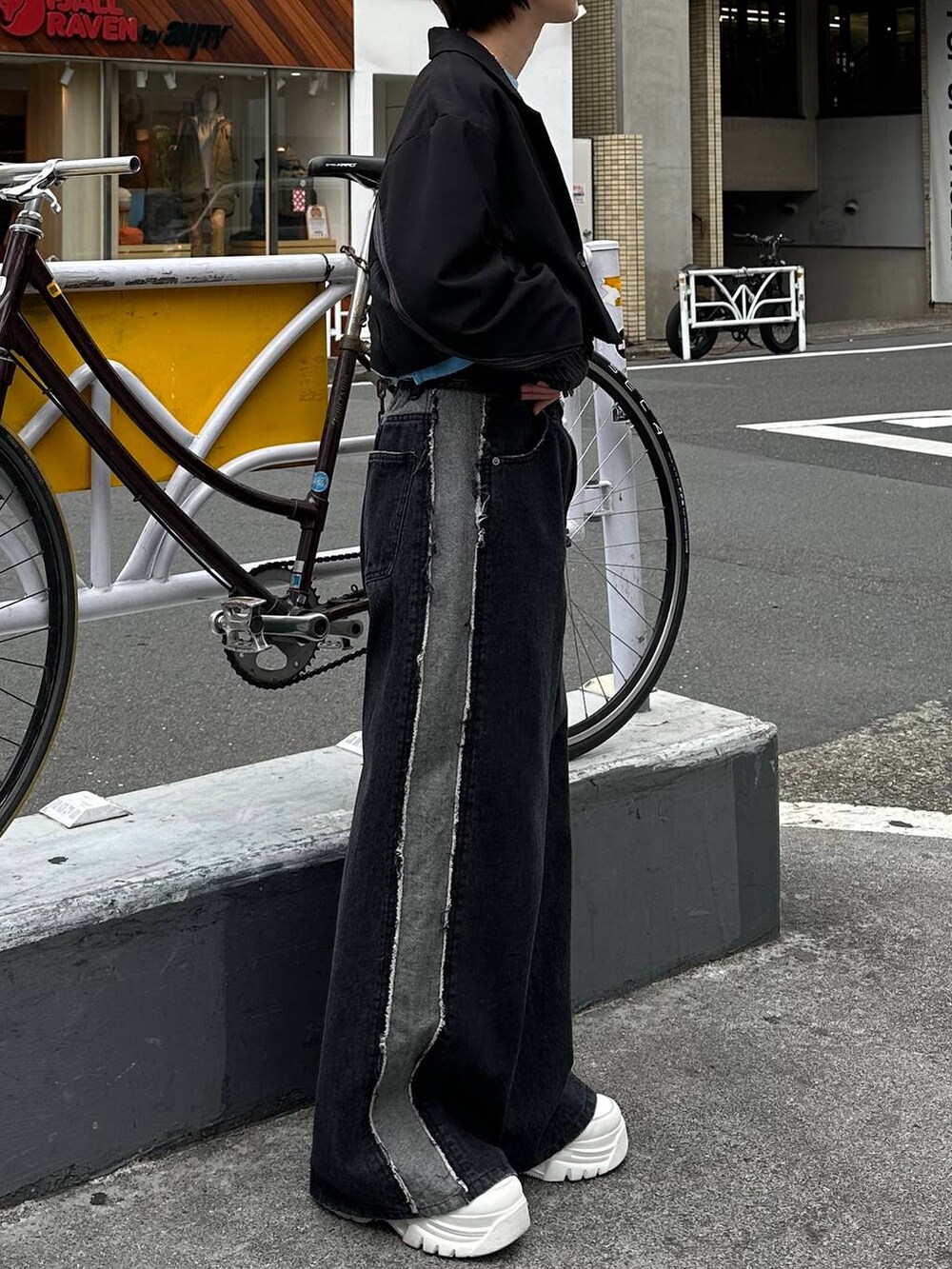 ブラック系のテーラードジャケット、ブラック系のデニムパンツ、ブルー系のスウェットを着用したレディースの春コーディネートの4枚目の写真