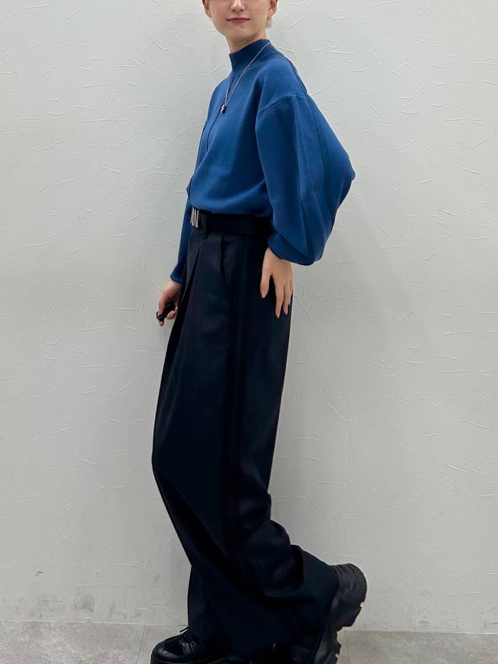 ブラック系のスニーカー、ブルー系のニット/セーター、ブラック系のスラックスを着用したレディースの秋コーディネートの3枚目の写真