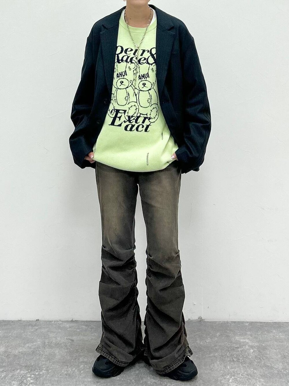 ブラック系のデニムパンツ、ブラック系のテーラードジャケット、グリーン系のニット/セーターを着用したレディースの秋コーディネートの2枚目の写真