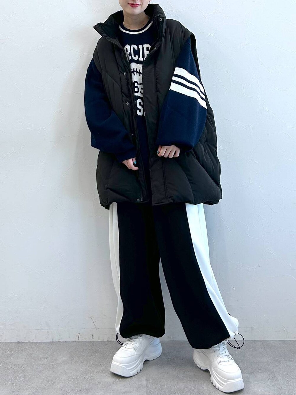 ブラック系のブルゾン、ブラック系のその他パンツ、ブルー系のニット/セーターを着用したレディースの冬コーディネートの2枚目の写真