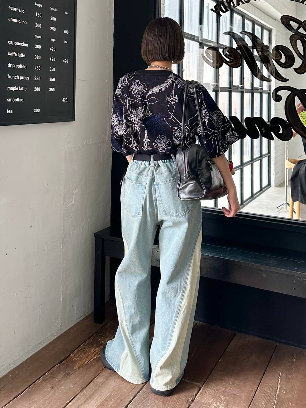 ブラック系のボストンバッグ、ブラック系のTシャツ/カットソー、ブルー系のデニムパンツを着用したレディースの春コーディネートの7枚目の写真