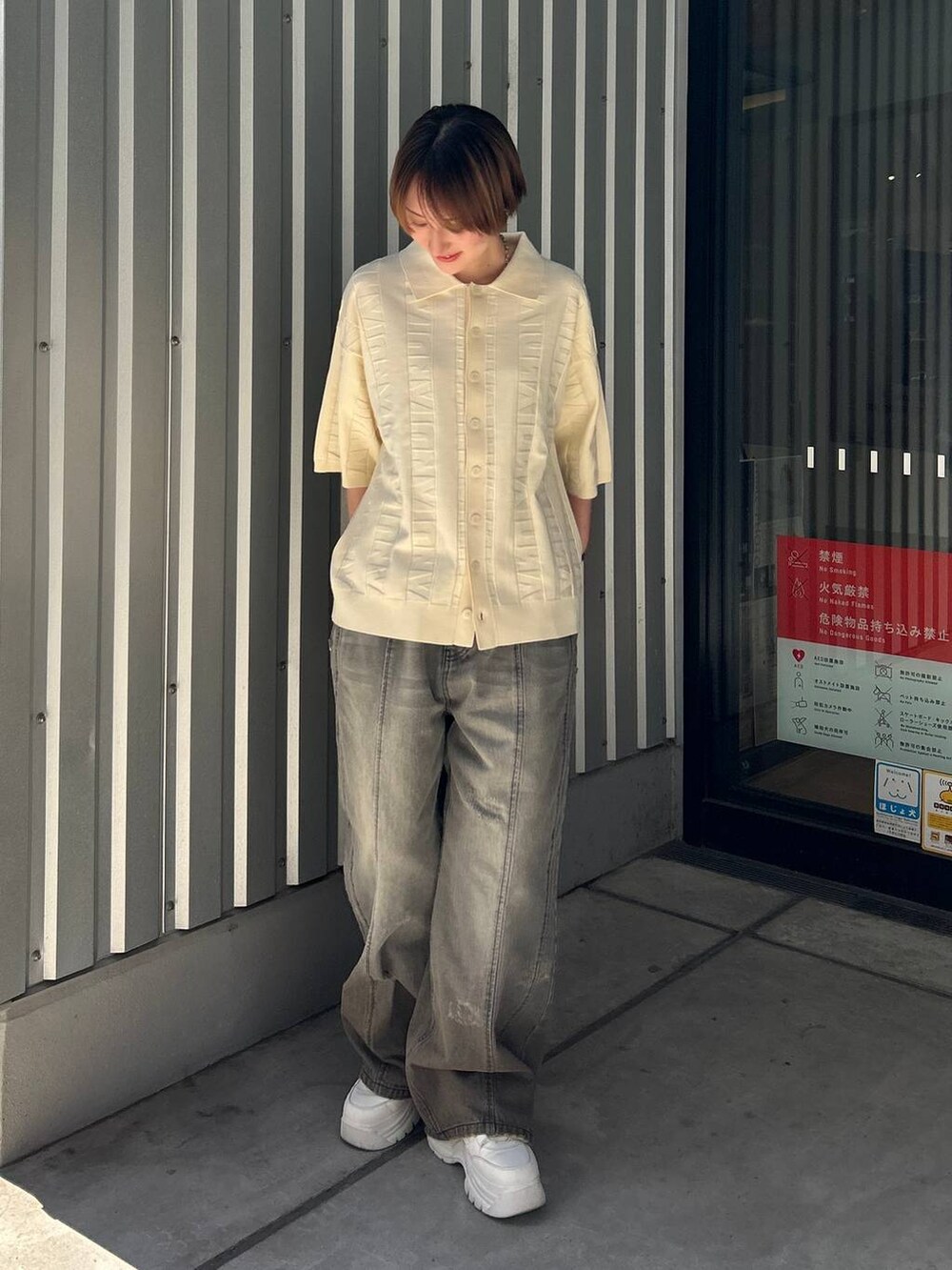 ブラック系のデニムパンツ、ホワイト系のニット/セーターを着用したレディースの春コーディネートの2枚目の写真