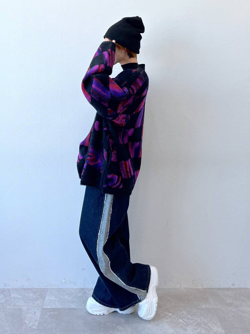 ブルー系のデニムパンツ、ブラック系のニット/セーター、ブラック系のニットキャップ/ビーニーを着用したレディースの秋コーディネートの5枚目の写真