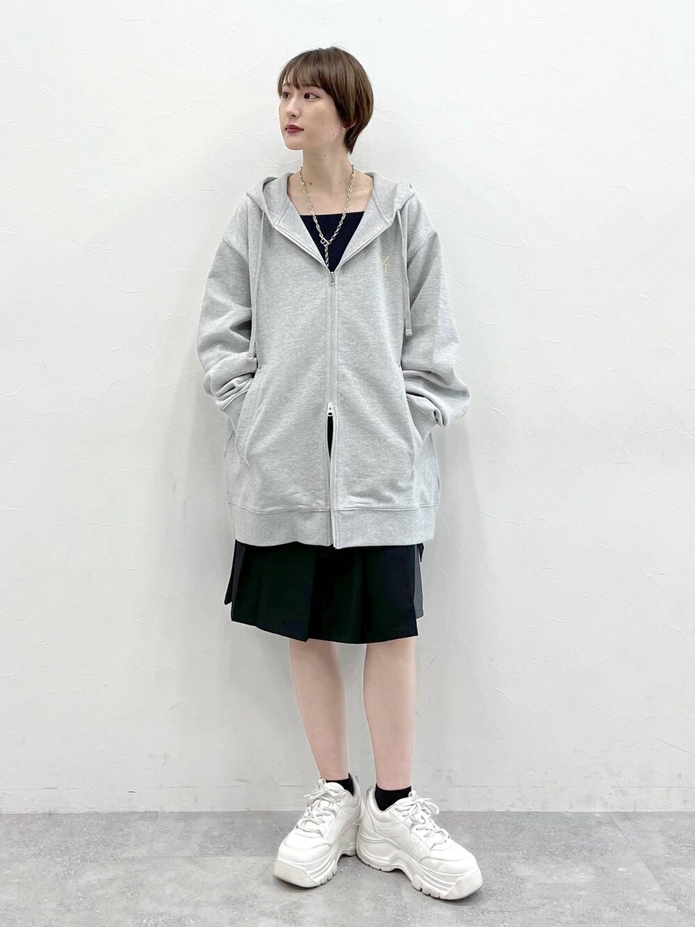 グレー系のパーカー、ブラック系のスラックスを着用したレディースの春コーディネートの2枚目の写真