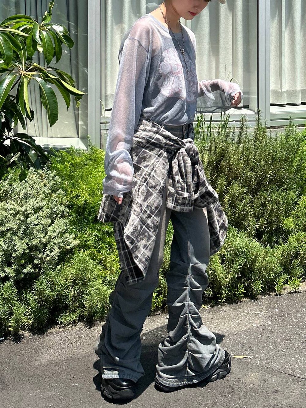 ブラック系のスニーカー、ブルー系のデニムパンツ、ブルー系のニット/セーターを着用したレディースの秋コーディネートの4枚目の写真