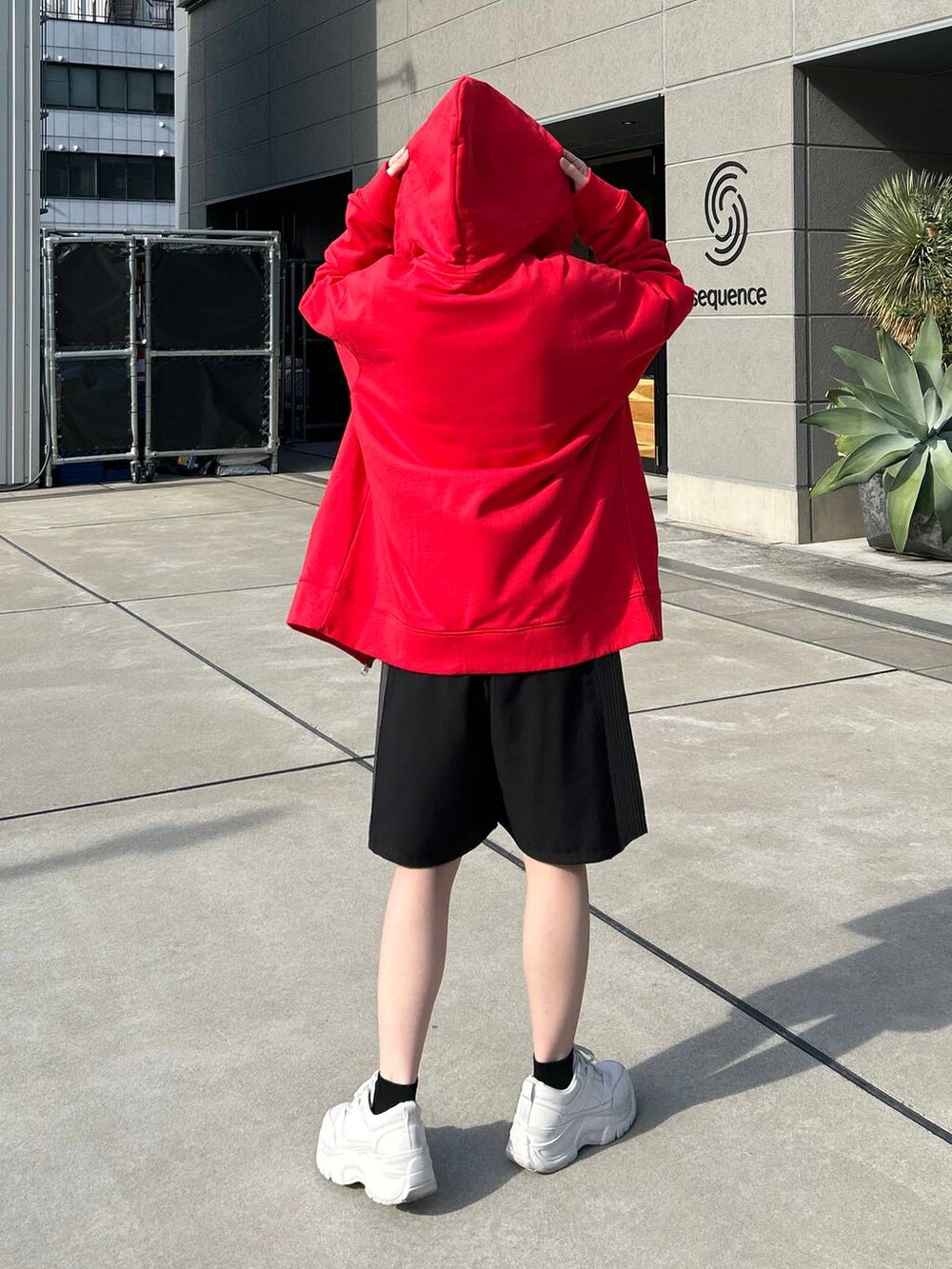 レッド系のパーカー、ホワイト系のニット/セーター、ブラック系のスラックスを着用したレディースの冬コーディネートの7枚目の写真