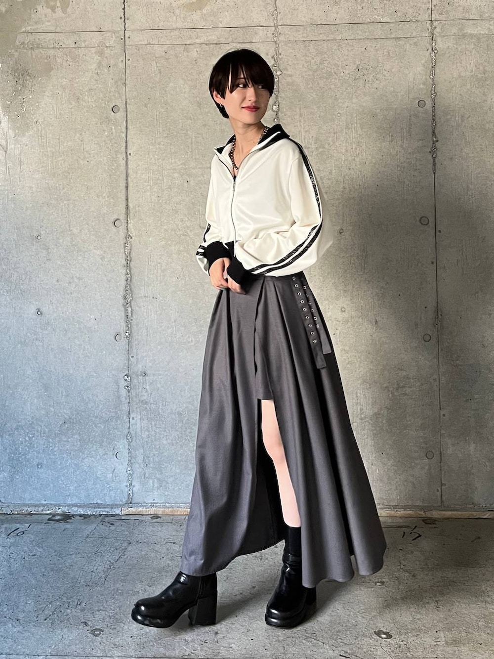 ブラック系のキャミソール、ブラック系のブーツ、グレー系のスカートを着用したレディースの冬コーディネートの2枚目の写真