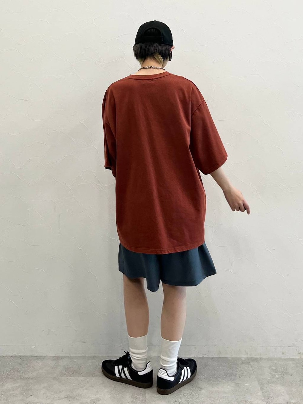 グレー系のその他パンツ、ブラック系のスニーカー、レッド系のTシャツ/カットソーを着用したレディースの春コーディネートの7枚目の写真