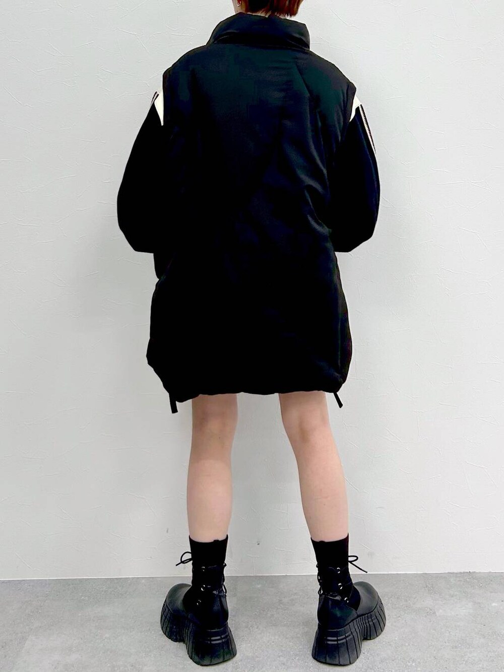 ブラック系のブルゾン、ブラック系のブーツ、ブラック系のスカートを着用したレディースの冬コーディネートの6枚目の写真