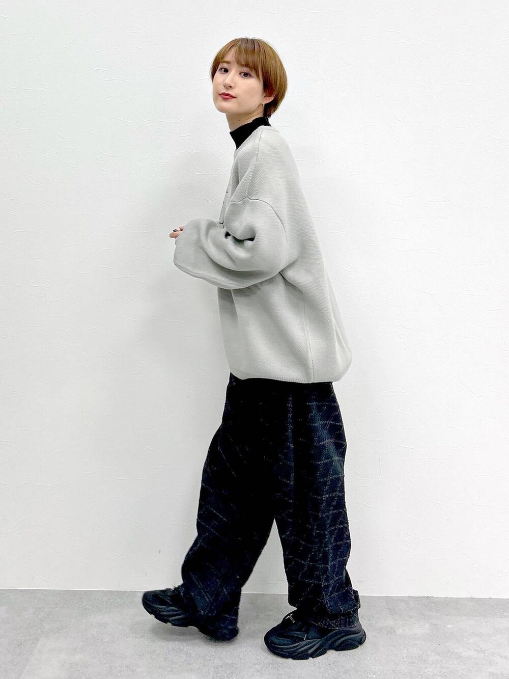 ブラック系のデニムパンツ、グレー系のニット/セーターを着用したレディースの冬コーディネートの3枚目の写真