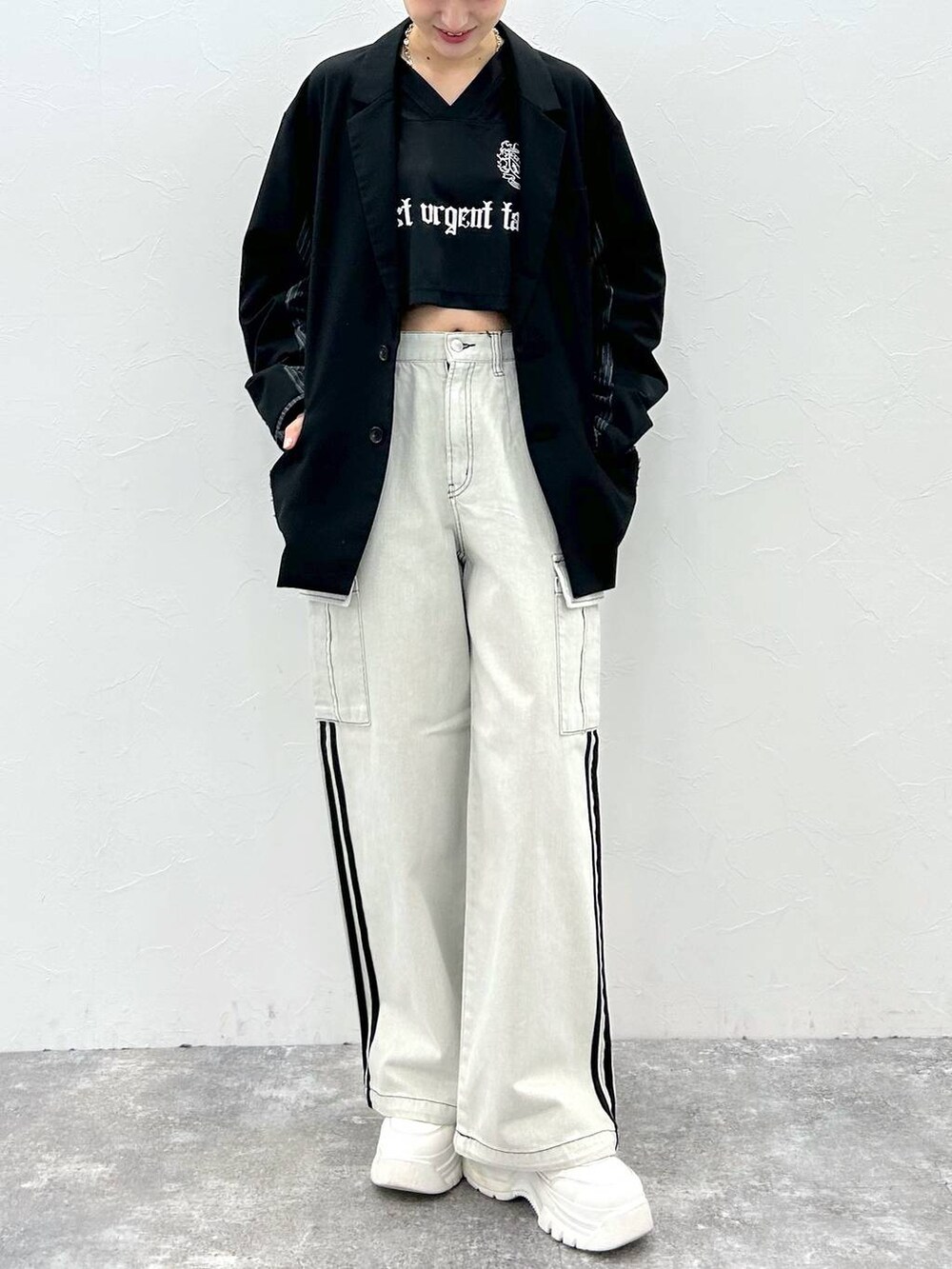 ブラック系のテーラードジャケット、ホワイト系のデニムパンツ、ブラック系のTシャツ/カットソーを着用したレディースの春コーディネートの2枚目の写真