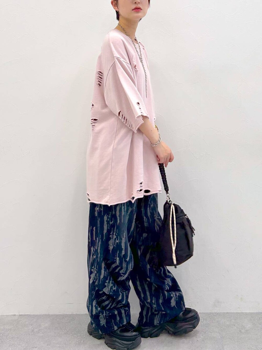 ブラック系のスニーカー、ブラック系のショルダーバッグ、ピンク系のTシャツ/カットソーを着用したレディースの夏コーディネートの7枚目の写真