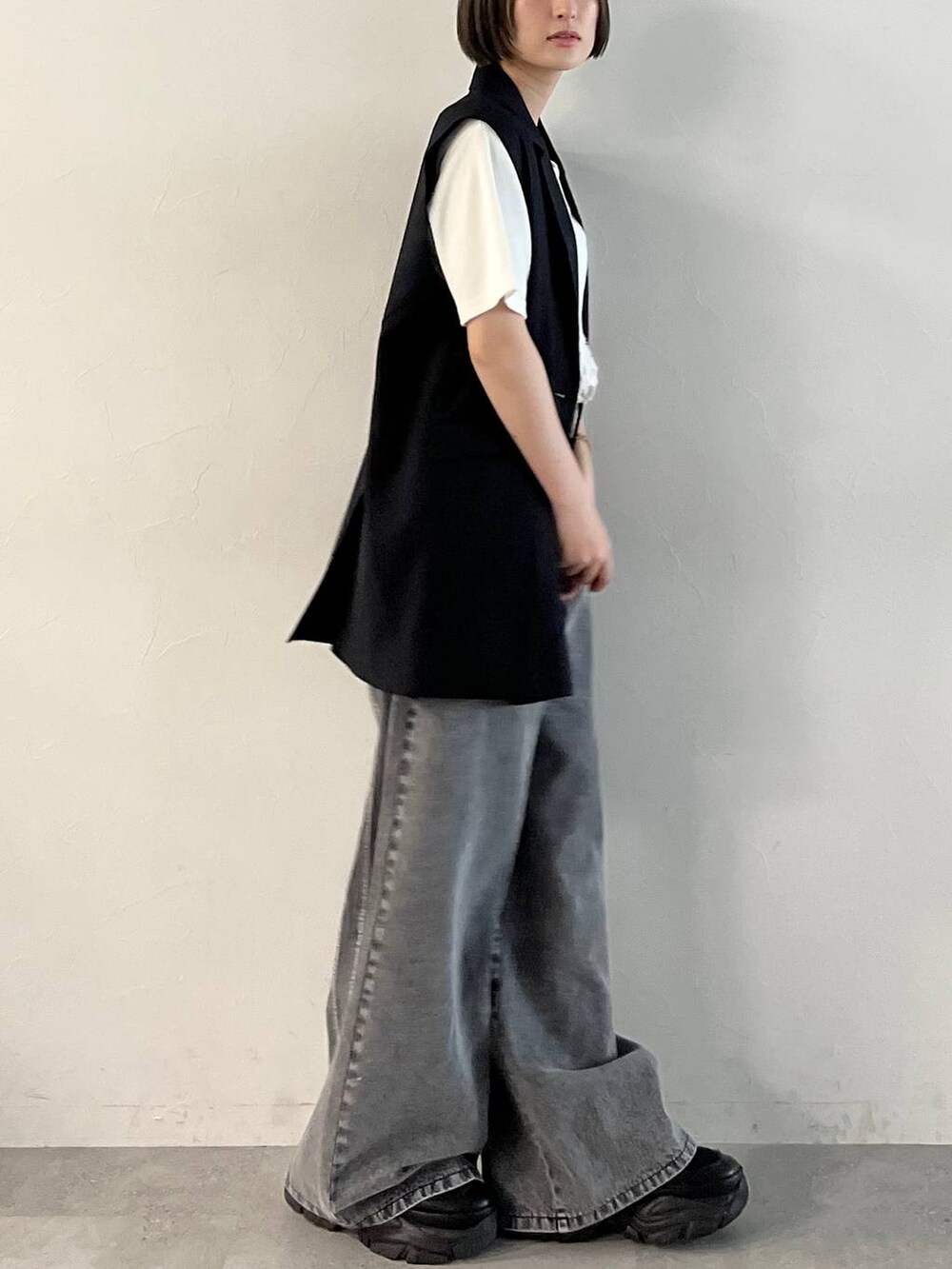 ブラック系のスニーカー、ブラック系のデニムパンツ、ブラック系のその他アウターを着用したレディースの春コーディネートの7枚目の写真