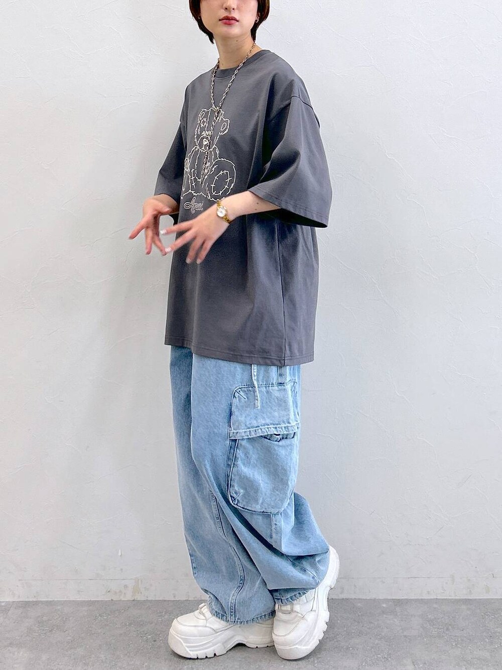 グレー系のTシャツ/カットソー、ブルー系のデニムパンツ、シルバー系のネックレスを着用したレディースの夏コーディネートの6枚目の写真