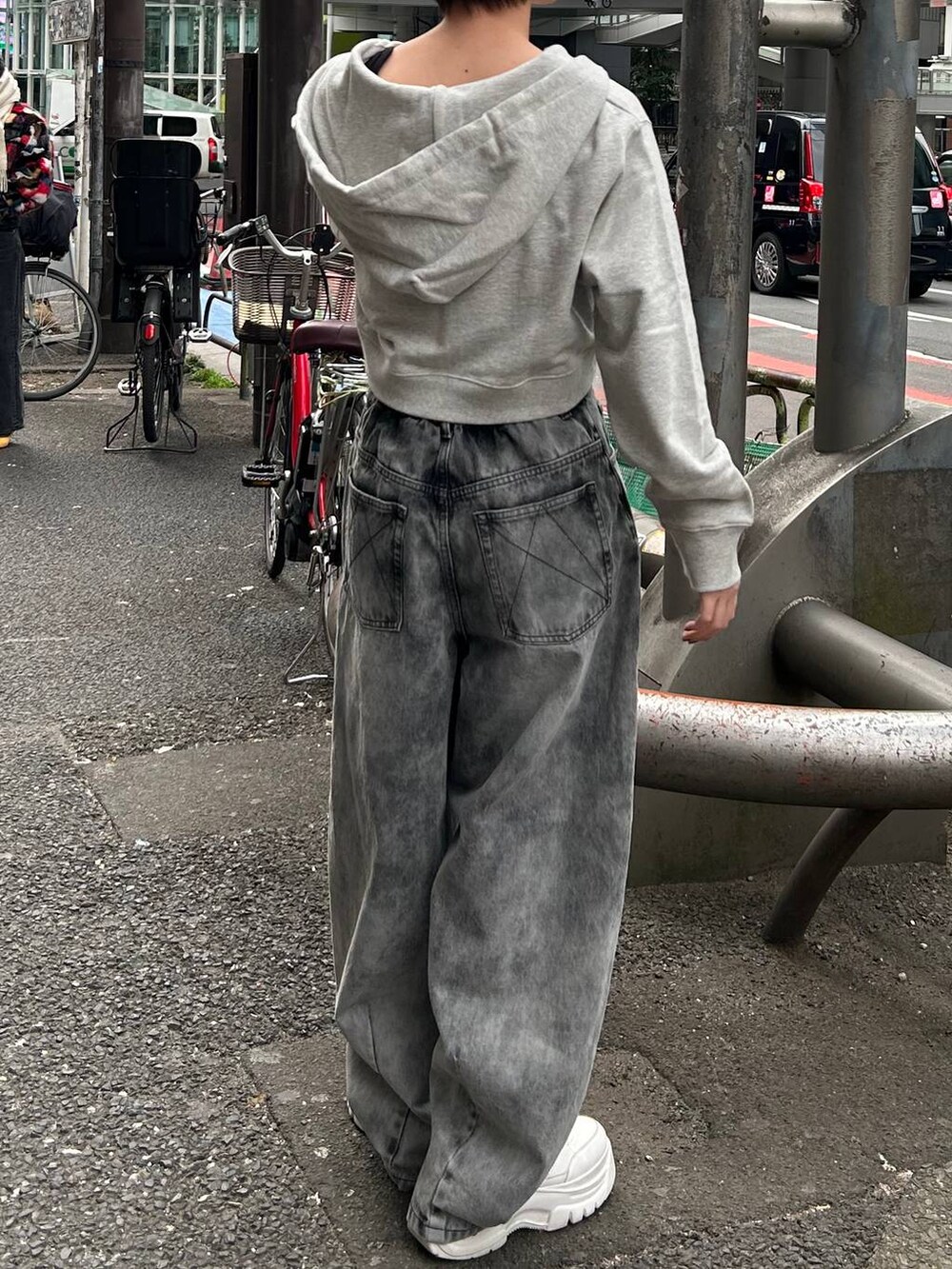 グレー系のパーカー、ブラック系のデニムパンツを着用したレディースの春コーディネートの5枚目の写真