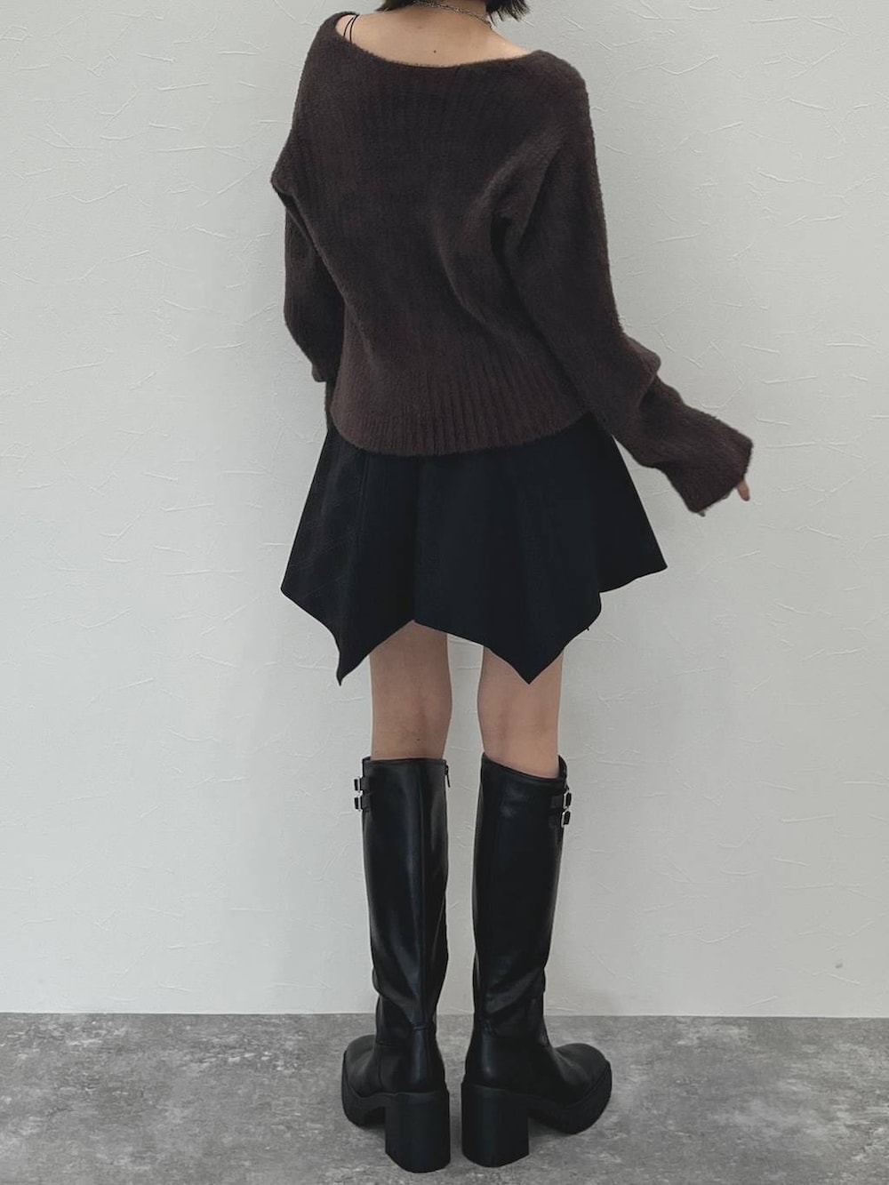 ブラック系のスカート、ブラウン系のニット/セーターを着用したレディースの秋コーディネートの6枚目の写真
