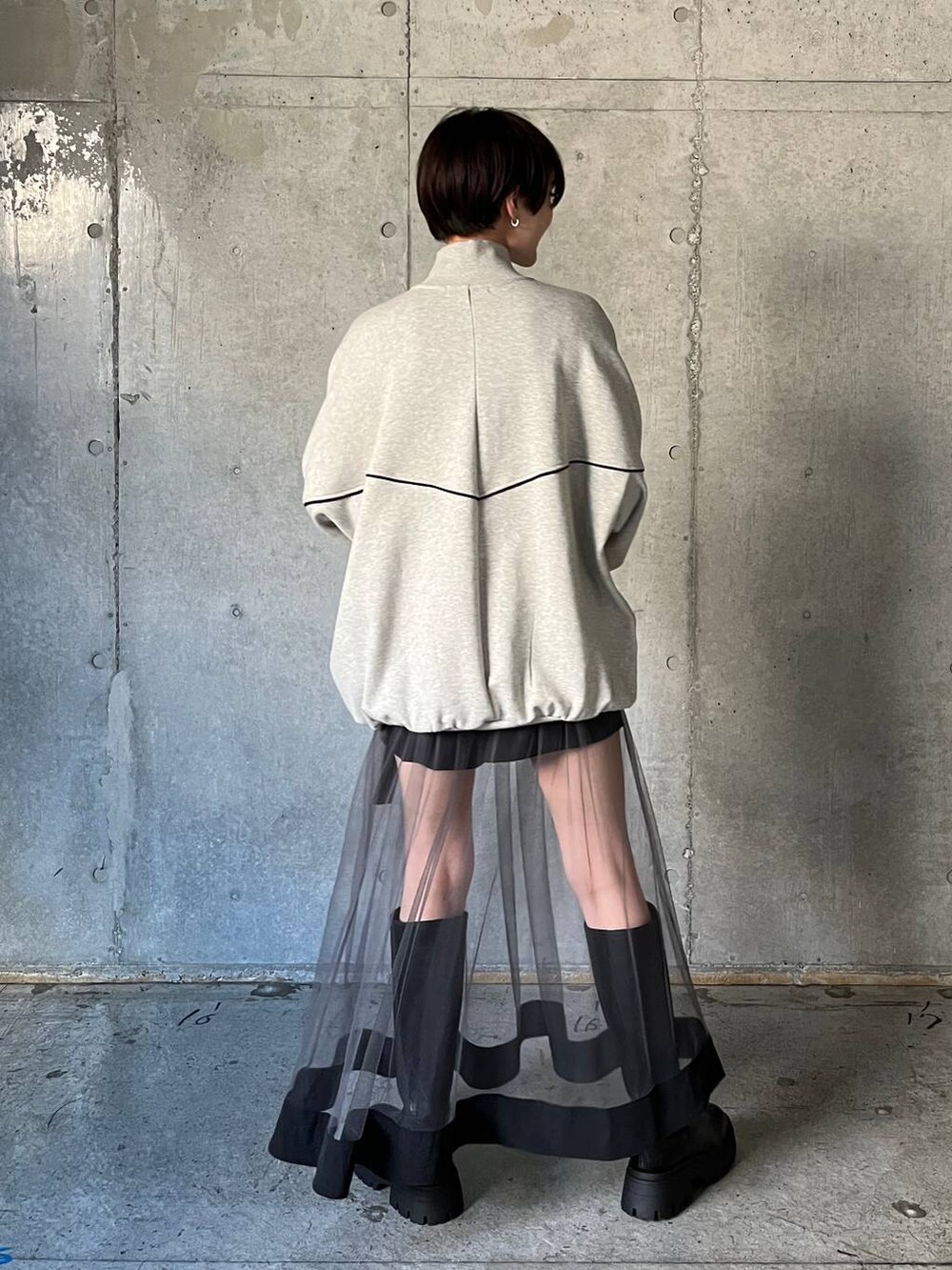 ブラック系のブーツ、グレー系のスウェット、グレー系のスカートを着用したレディースの冬コーディネートの6枚目の写真