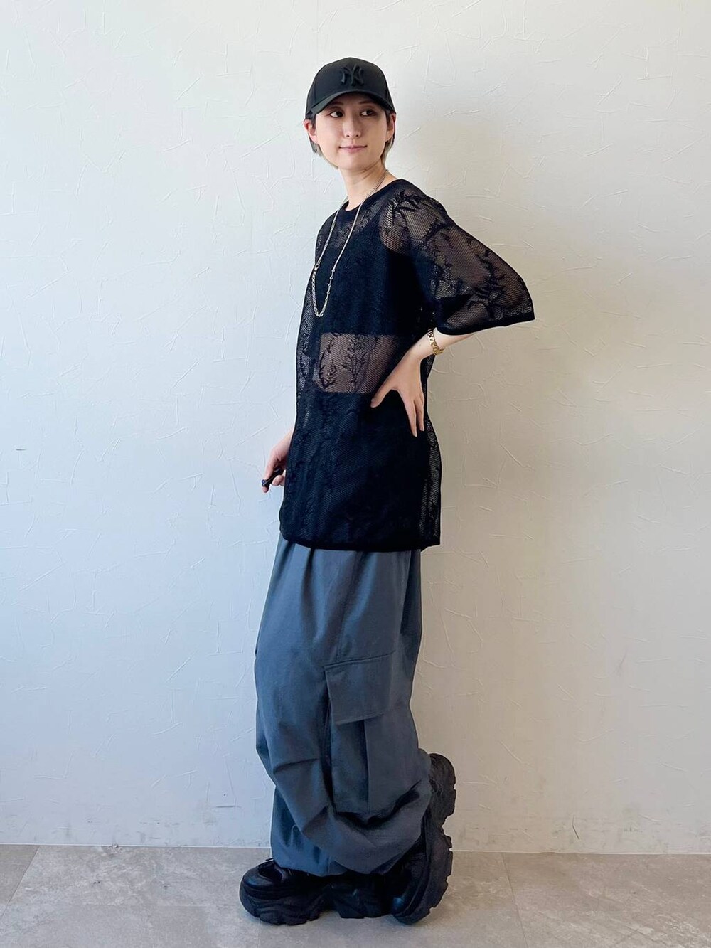 ブラック系のスニーカー、グレー系のカーゴパンツ、ブラック系のキャミソールを着用したレディースの春コーディネートの3枚目の写真