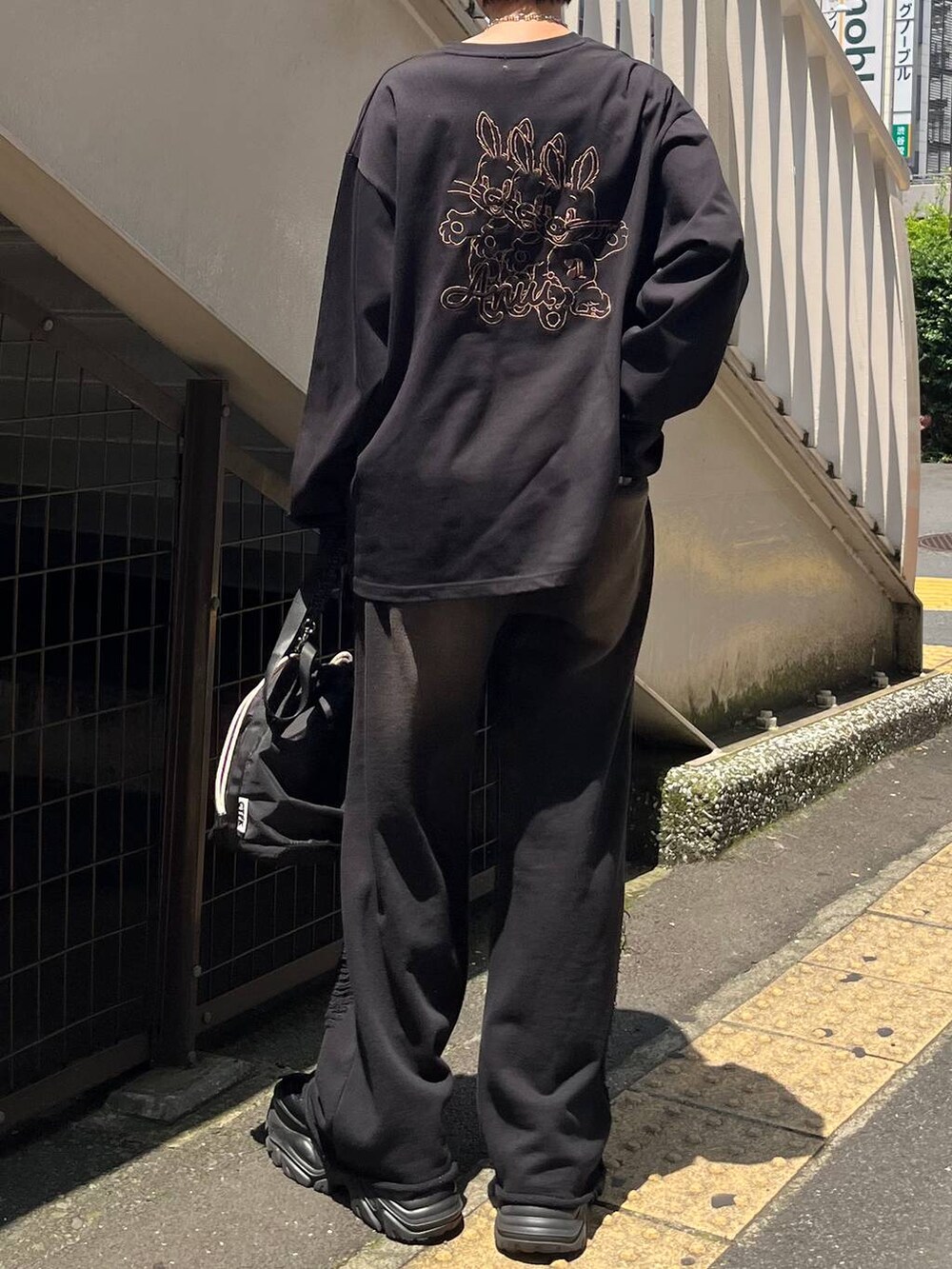 ブラック系のショルダーバッグ、ブラック系のスニーカー、ブラック系のスウェットパンツを着用したレディースの秋コーディネートの2枚目の写真