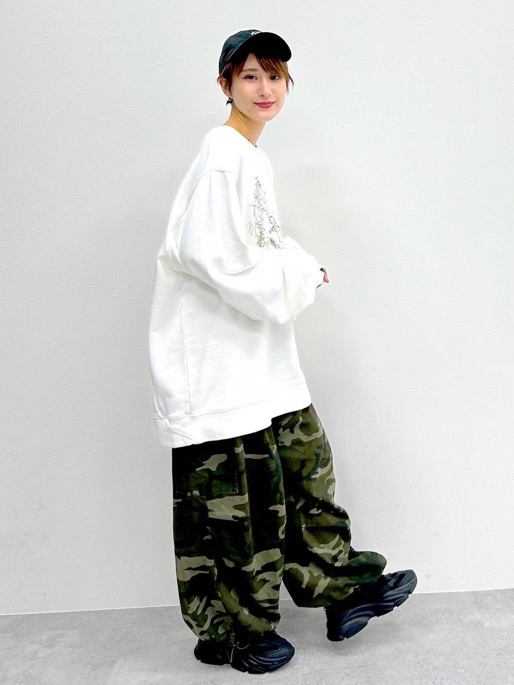 グリーン系のその他パンツ、ホワイト系のスウェット、ブラック系のキャップを着用したレディースの冬コーディネートの5枚目の写真