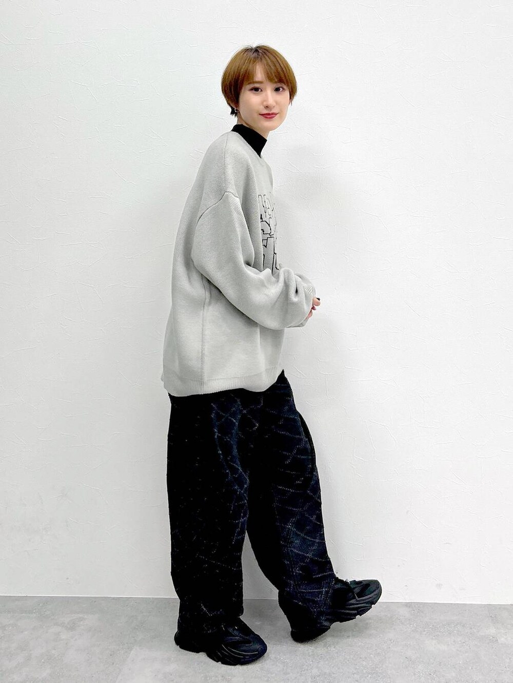 ブラック系のデニムパンツ、グレー系のニット/セーターを着用したレディースの冬コーディネートの5枚目の写真