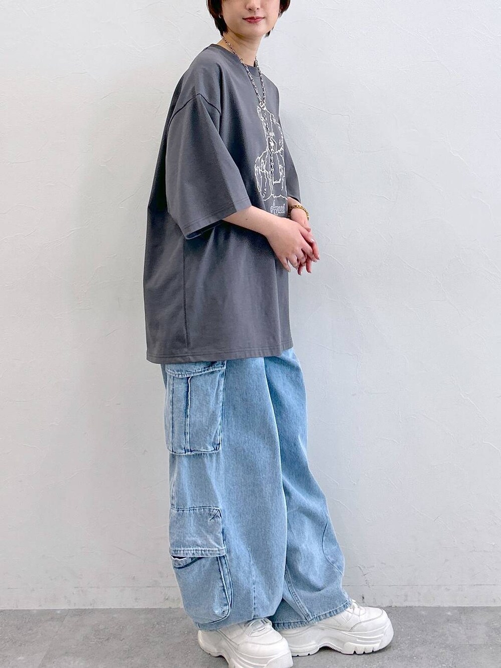 グレー系のTシャツ/カットソー、ブルー系のデニムパンツ、シルバー系のネックレスを着用したレディースの夏コーディネートの4枚目の写真