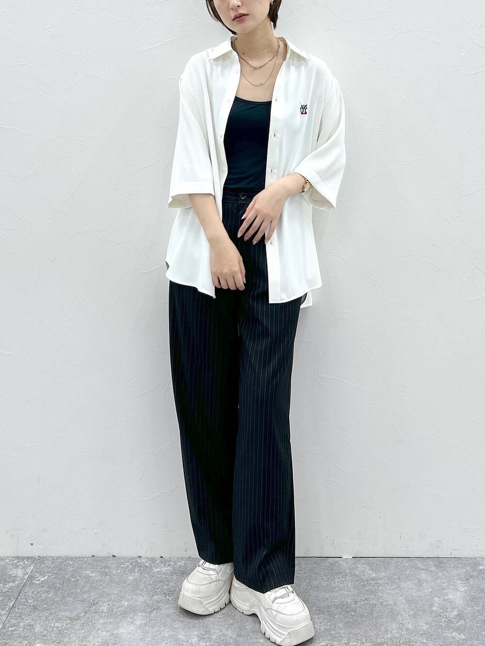 ホワイト系のシャツ/ブラウス、ブラック系のスラックスを着用したレディースの春コーディネートの2枚目の写真