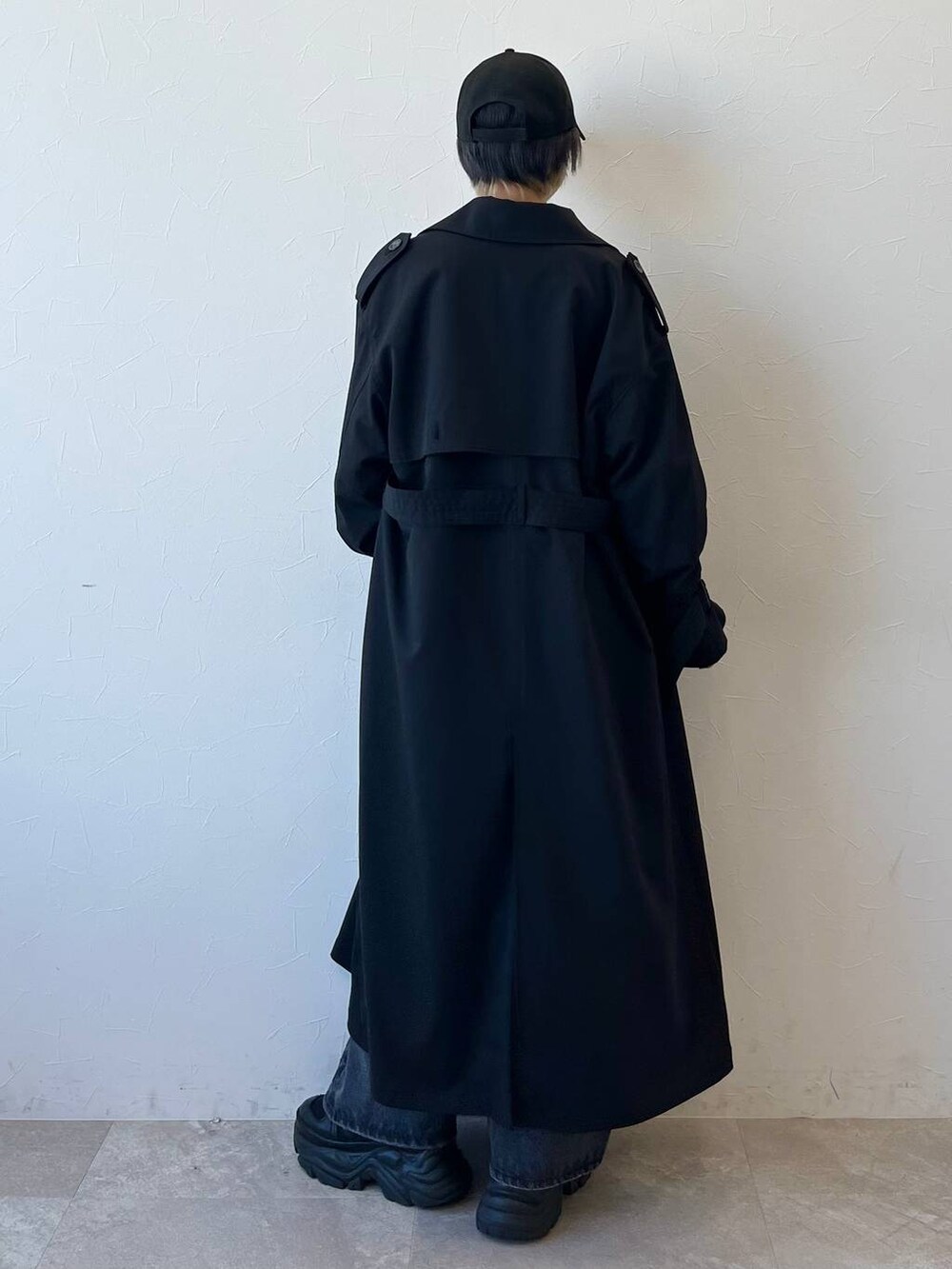 ブラック系のスニーカー、ブラック系のトレンチコート、ブラック系のデニムパンツを着用したレディースの春コーディネートの8枚目の写真