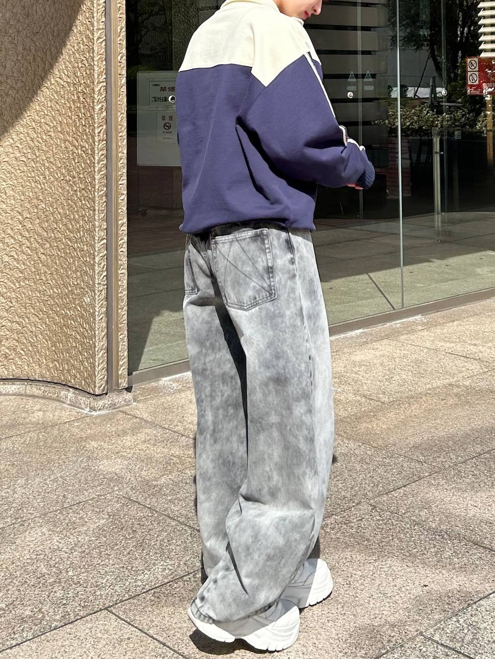 ブルー系のスウェット、ブラック系のデニムパンツを着用したレディースの春コーディネートの4枚目の写真