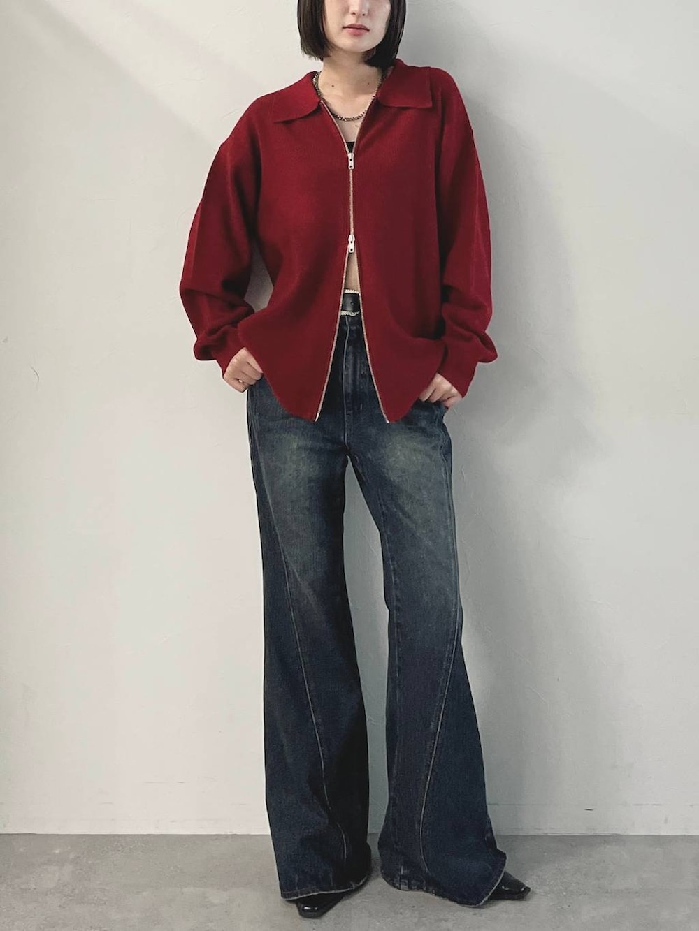 ブラック系のキャミソール、ブルー系のデニムパンツ、ブラック系のパンプスを着用したレディースの秋コーディネートの2枚目の写真