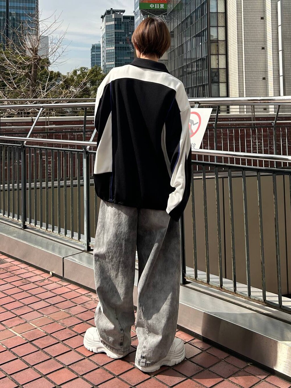 ブラック系のポロシャツ、ブラック系のデニムパンツを着用したレディースの春コーディネートの7枚目の写真