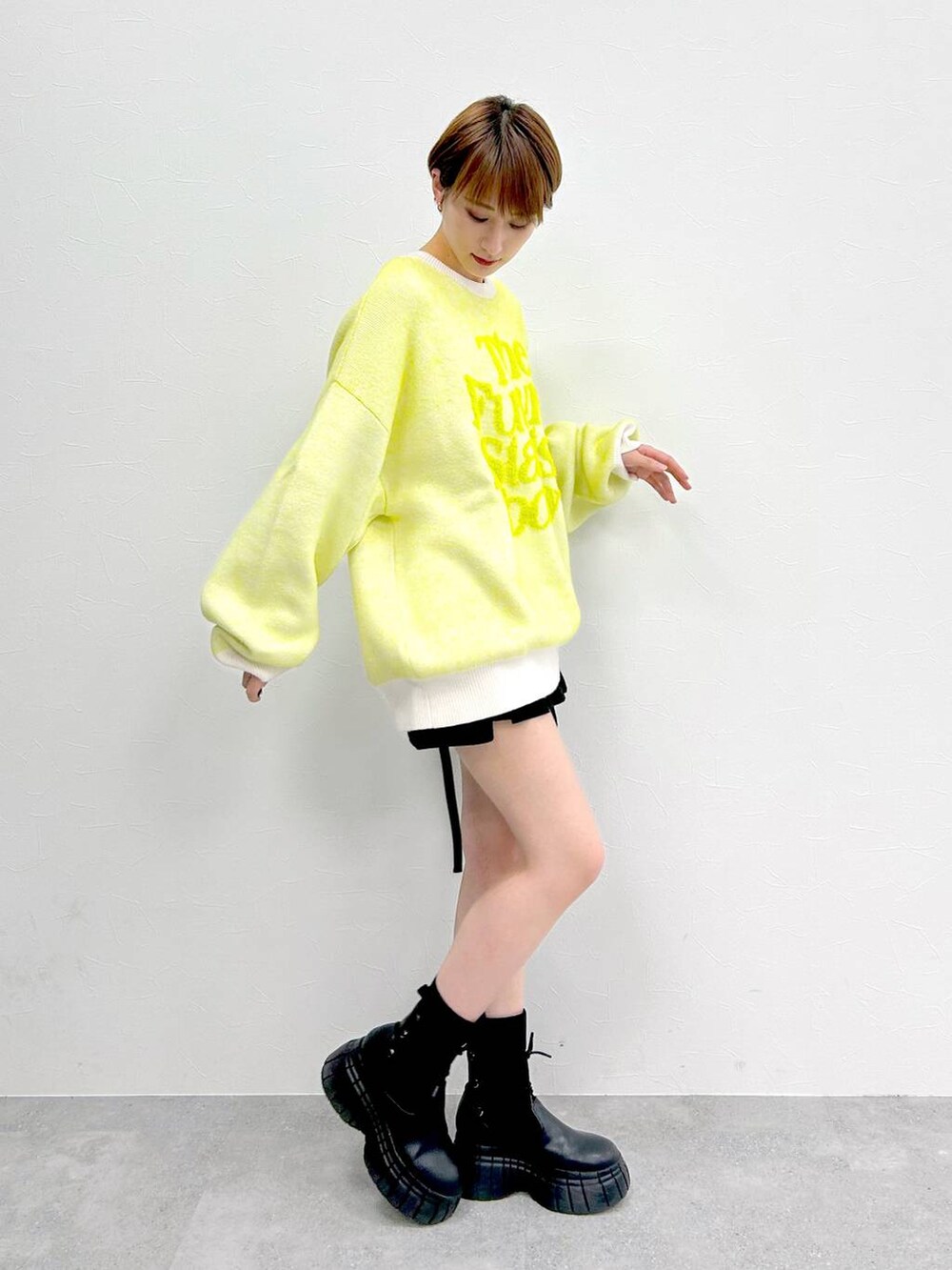 ホワイト系のニット/セーター、ブラック系のブーツ、ブラック系のスカートを着用したレディースの冬コーディネートの5枚目の写真