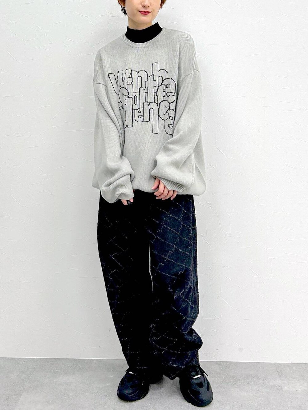 ブラック系のデニムパンツ、グレー系のニット/セーターを着用したレディースの冬コーディネートの2枚目の写真