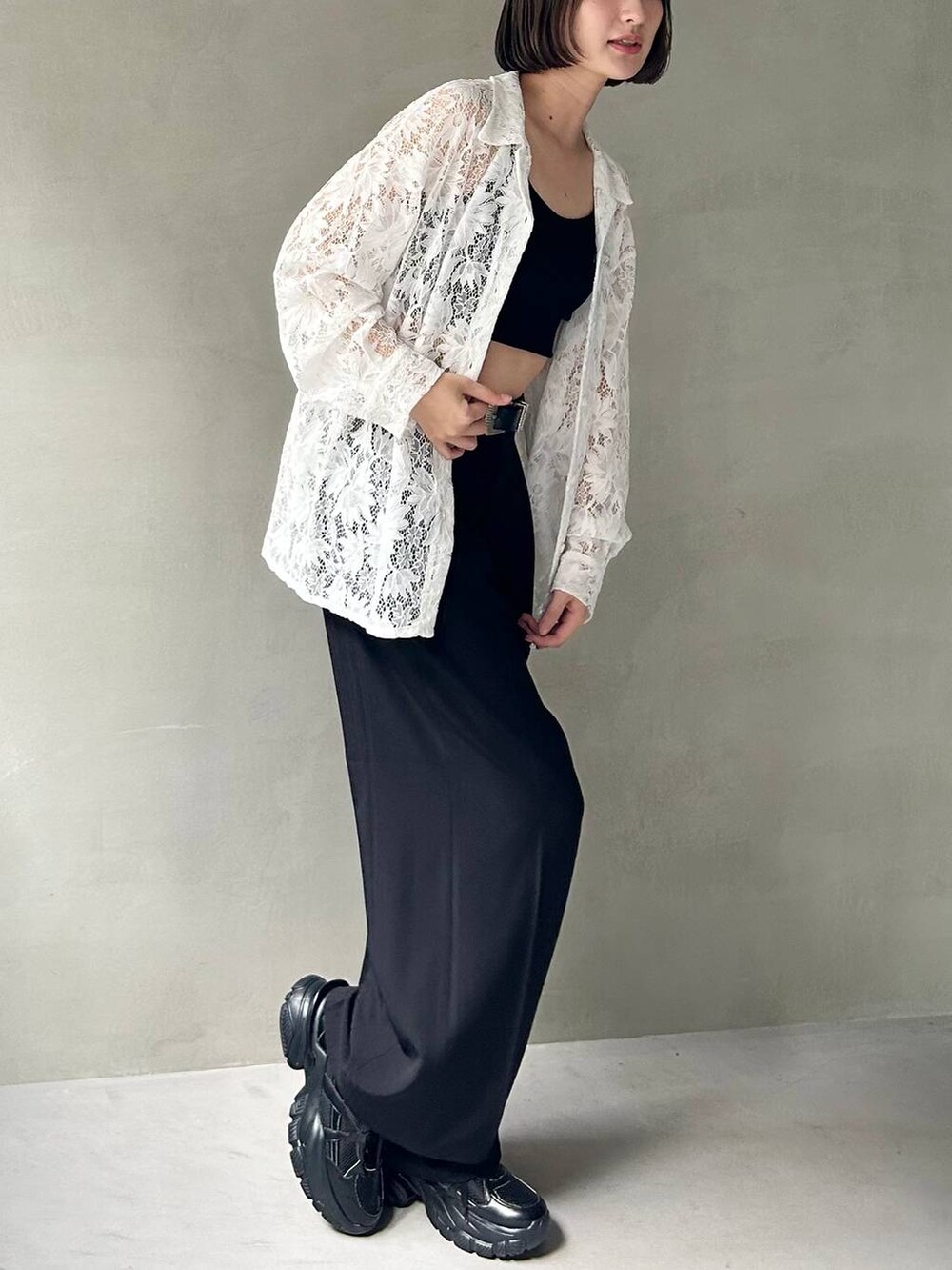 ブラック系のキャミソール、ブラック系のスラックス、ブラック系のスニーカーを着用したレディースの夏コーディネートの4枚目の写真