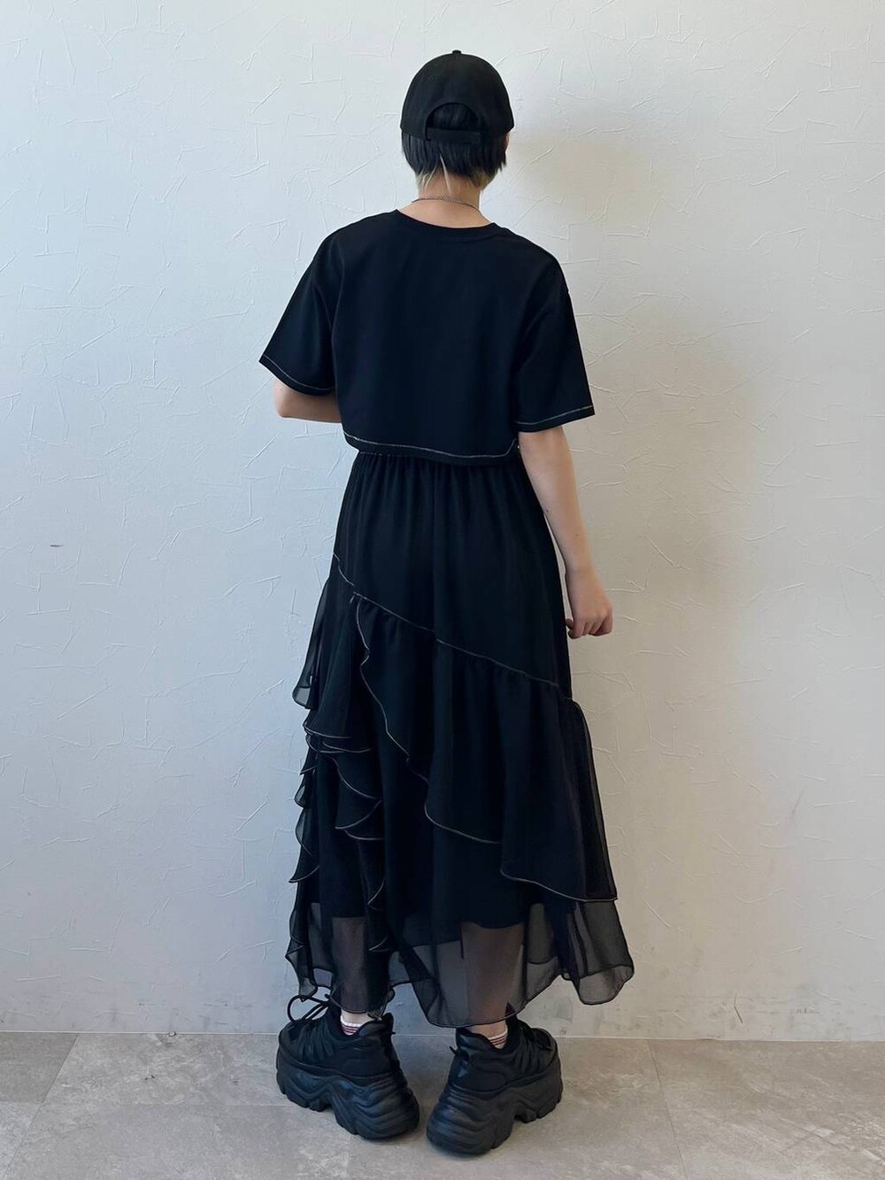 ブラック系のスニーカー、ブラック系のスカート、ブラック系のTシャツ/カットソーを着用したレディースの春コーディネートの7枚目の写真