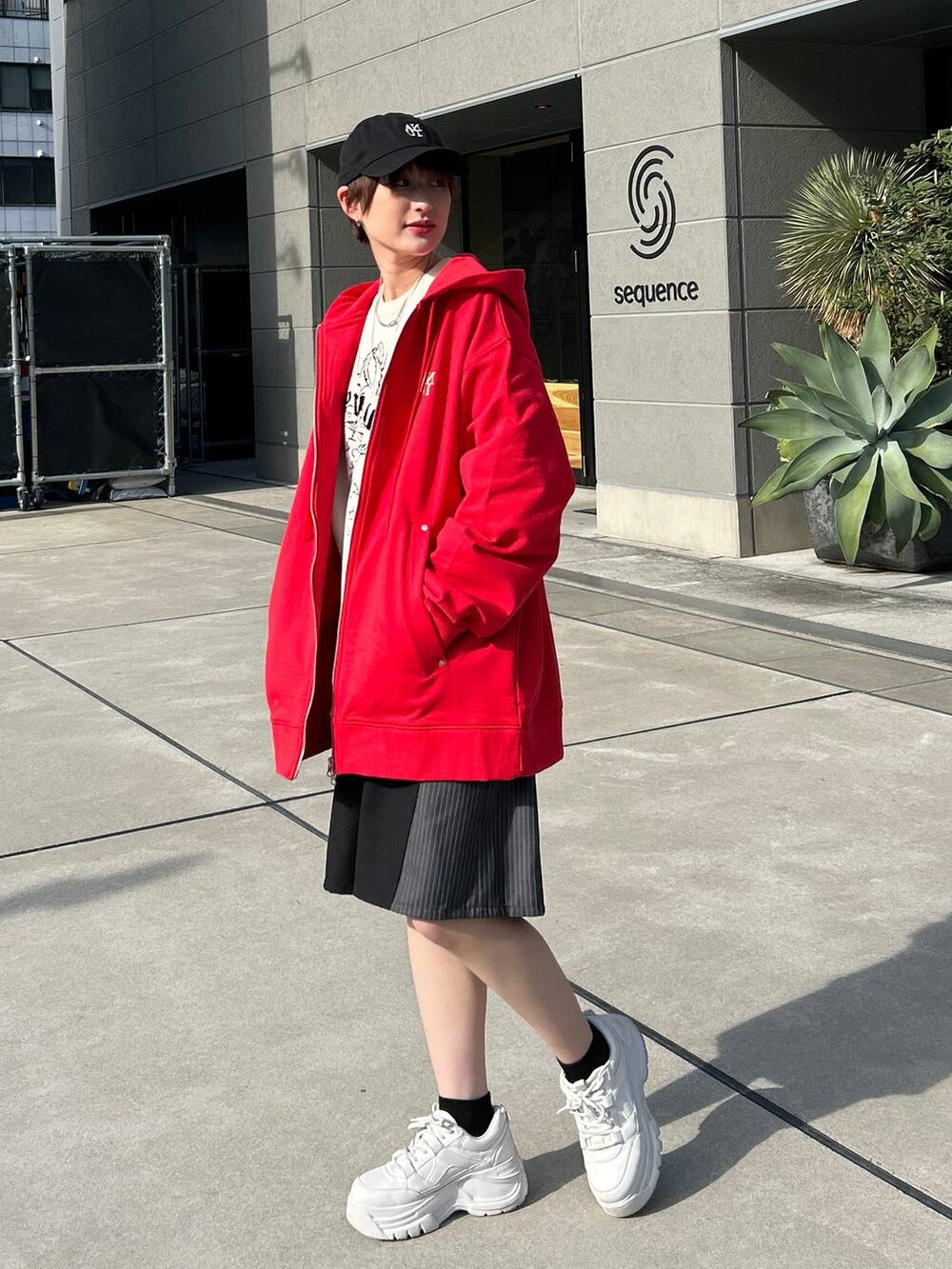 レッド系のパーカー、ホワイト系のニット/セーター、ブラック系のスラックスを着用したレディースの冬コーディネートの4枚目の写真