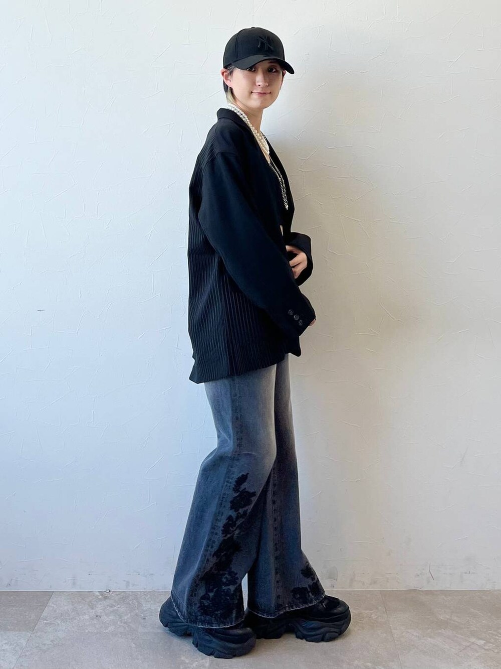 ブラック系のスニーカー、ブラック系のキャミソール、ブラック系のテーラードジャケットを着用したレディースの春コーディネートの5枚目の写真