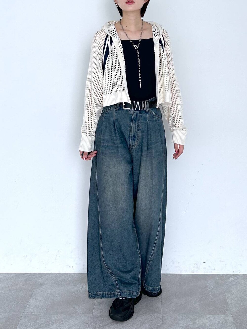 ブルー系のデニムパンツ、ホワイト系のパーカー、ブラック系のベルトを着用したレディースの夏コーディネートの2枚目の写真