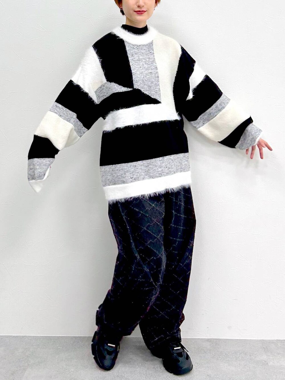 ブラック系のデニムパンツ、グレー系のニット/セーターを着用したレディースの冬コーディネートの2枚目の写真